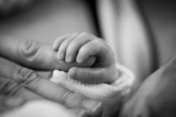 infant holding adult finger; setting boundaries