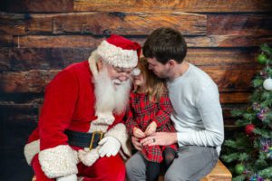 girl telling Santa what she wants for Christmas