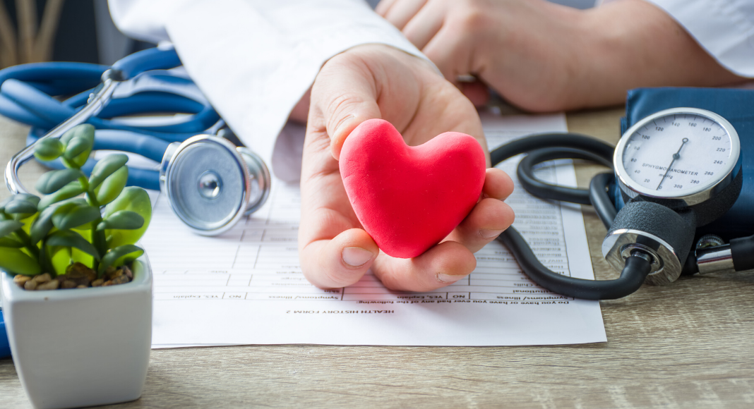 doctor holding heart; heart disease