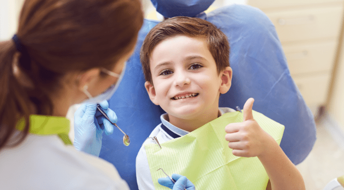 is it safe to go back to the dentist, child giving thumbs up