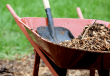 Outdoor jobs; Wheelbarrow full of mulch with shovel.