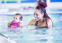 swimming and water safety; mother holds infant in pool